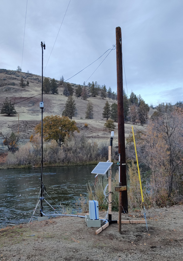 Hyperspectral sensor and monitoring equipment installed at Iron Gate on the Klamath River — sensor pole, solar panel, and data logger beside the river