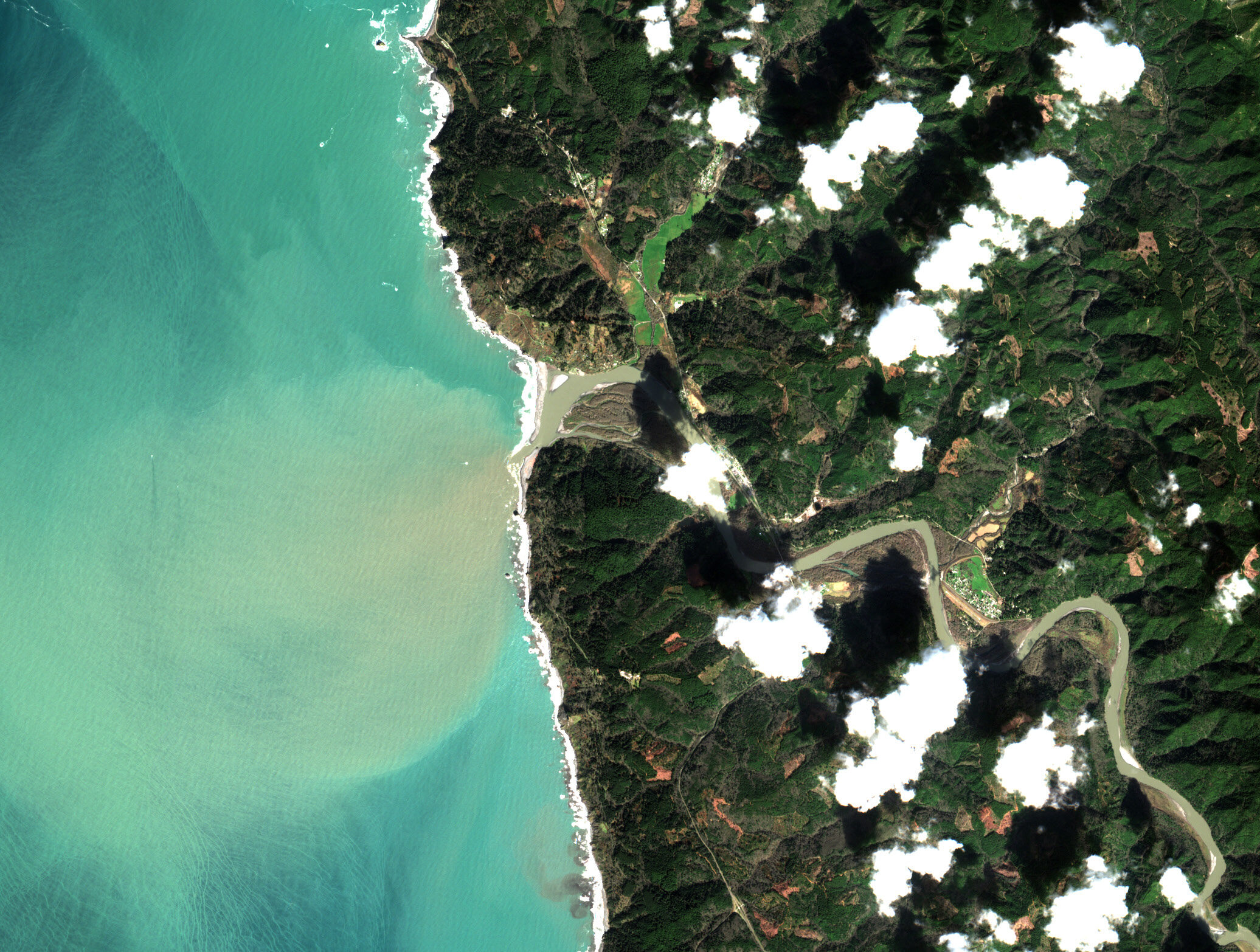 Sentinel-2 satellite image of the Klamath River mouth at the Pacific Ocean — sediment-laden river water visible as a brown plume dispersing into turquoise ocean